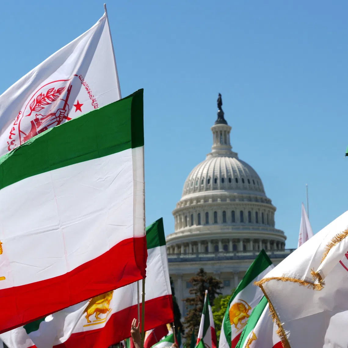 Flags are held by Iranian Americans and supporters of the National Council of Resistance of Iran during a march near the U.S. Capitol in Washington, D.C., U.S., May 16, 2026. REUTERS/Ken Cedeno/File Photo