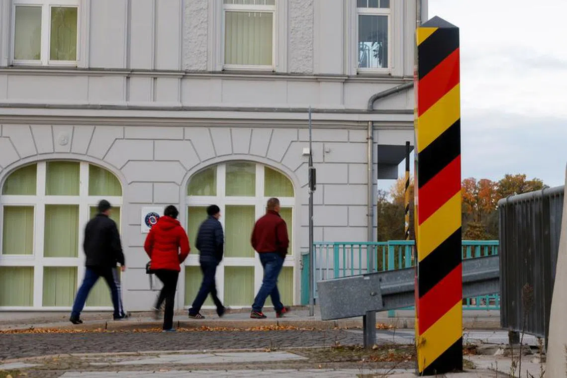 People cross the border between Germany and Poland in Guben, Germany, October 23, 2021. REUTERS/Michele Tantussi/ File Photo