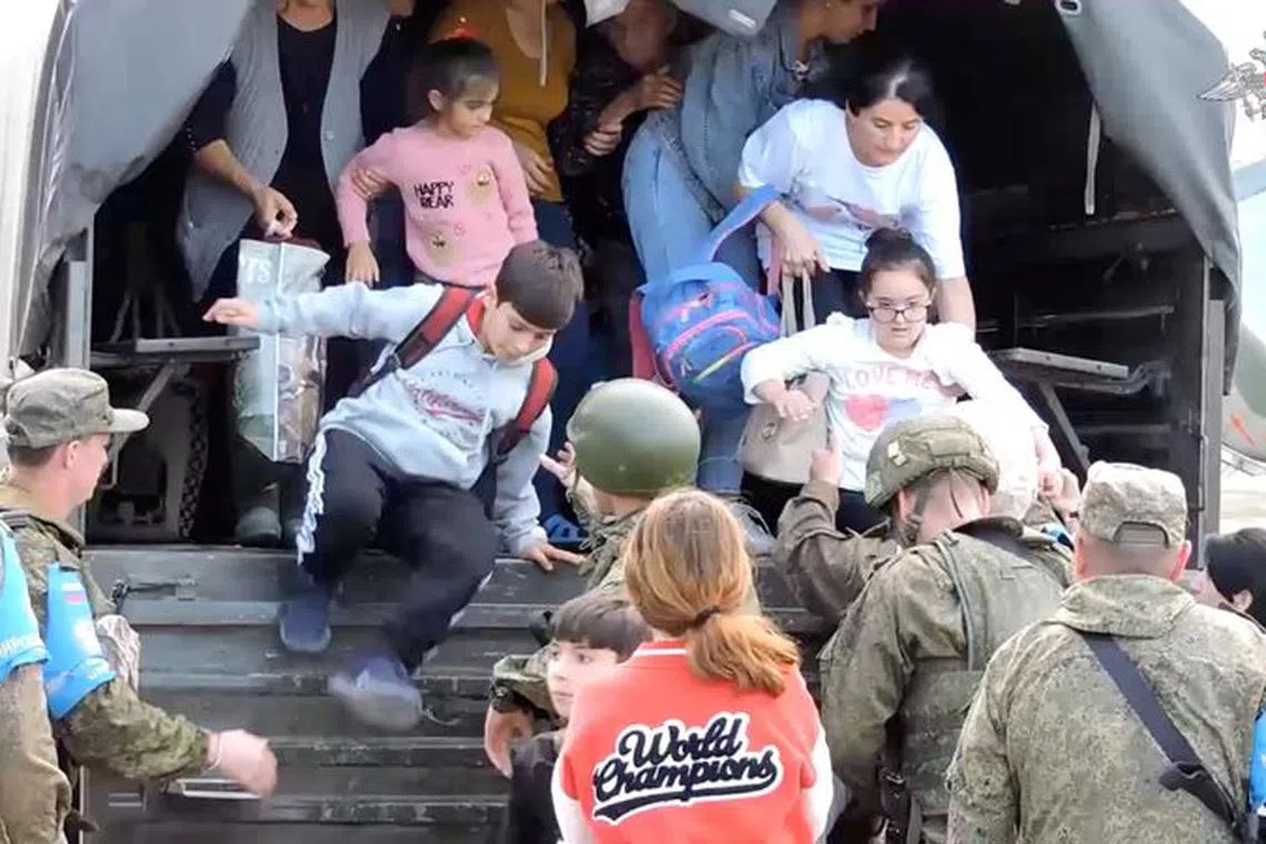 FILE PHOTO: Civilians get out of a truck during an evacuation performed by Russian peacekeepers at an unknown location following the launch of a military operation by Azerbaijani forces in Nagorno-Karabakh, a region inhabited by ethnic Armenians, in this still image from video published September 20, 2023. Russian Defence Ministry/Handout via REUTERS