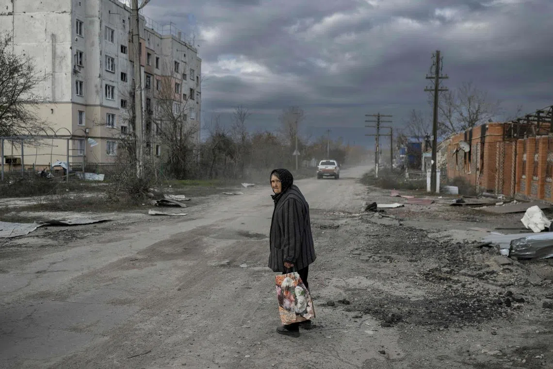 TOPSHOT - An old woman walks in the Kherson region village of Arkhanhelske on November 3, 2022, which was formerly occupied by Russian forces. (Photo by BULENT KILIC / AFP)