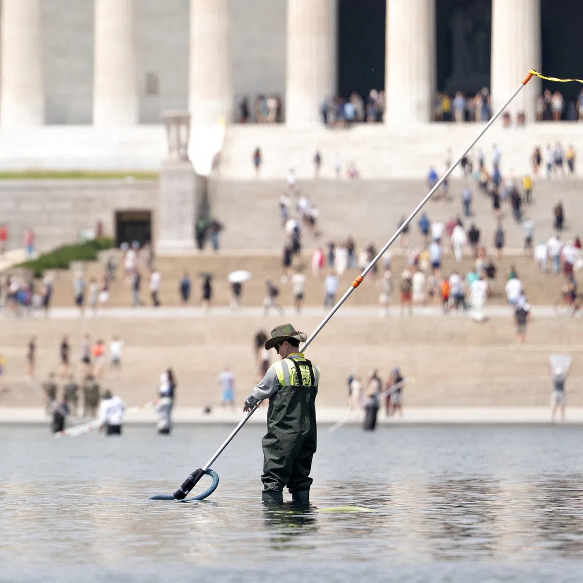 FILE PHOTO: A worker vacuums algae from the Lincoln Memorial Reflecting Pool, after recent renovations following a directive from U.S. President Donald Trump to paint it blue ahead of the 250th anniversary of U.S. Independence, in Washington, D.C., U.S., June 21, 2026. REUTERS/Aaron Schwartz/File Photo
