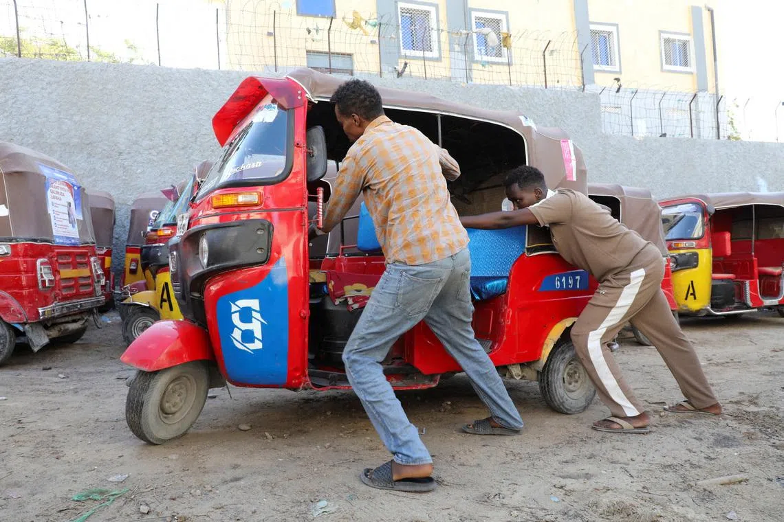 Operators of rickshaw taxis push a vehicle to a parking yard following high fuel prices, amid the U.S.-Israeli conflict with Iran, in Mogadishu, Somalia, March 25, 2026 REUTERS/Feisal Omar