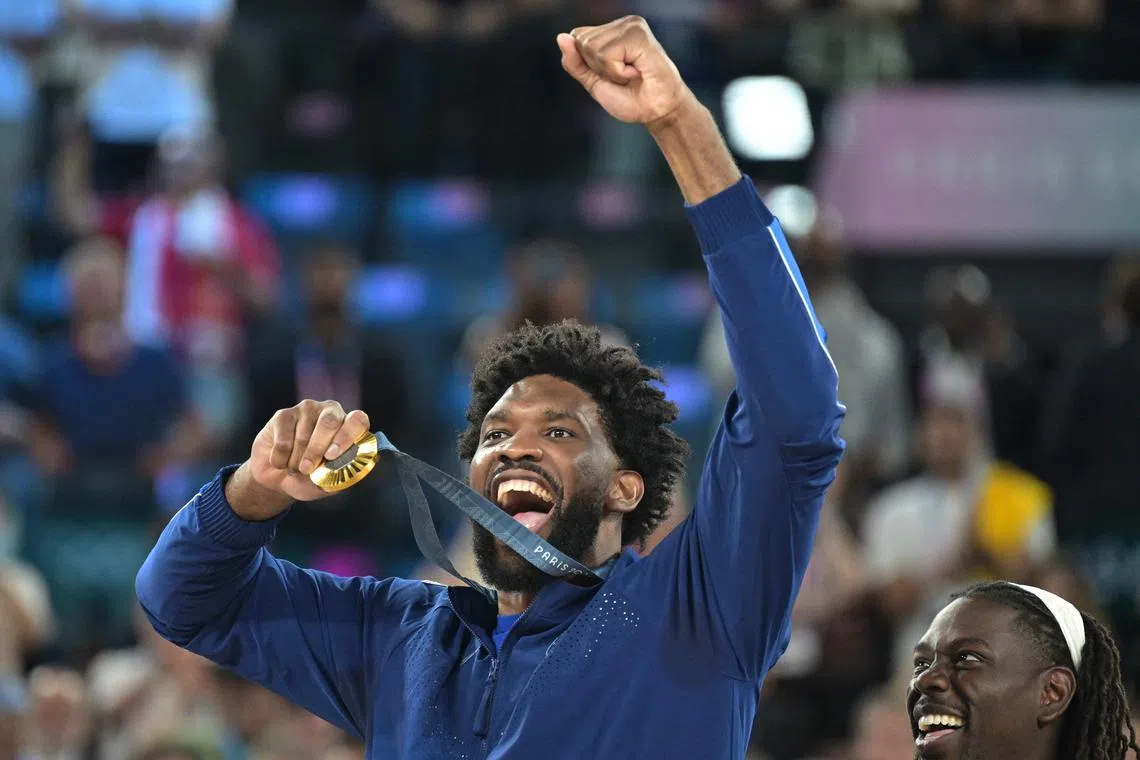 Joel Embiid celebrates on the podium after winning Olympic gold at the Paris Games.