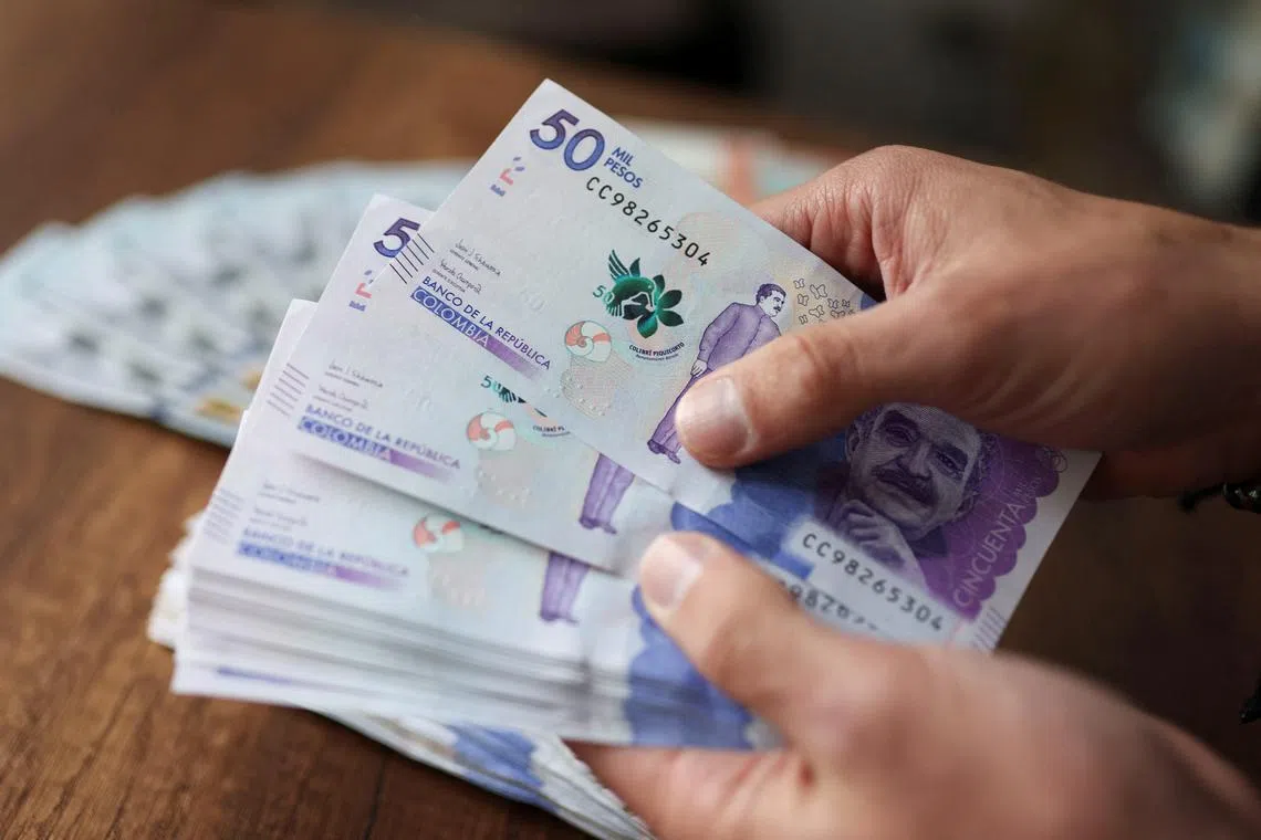 An employee counts Colombian pesos in an exchange house, in Bogota, Colombia July 11, 2022. REUTERS/Luisa Gomzalez