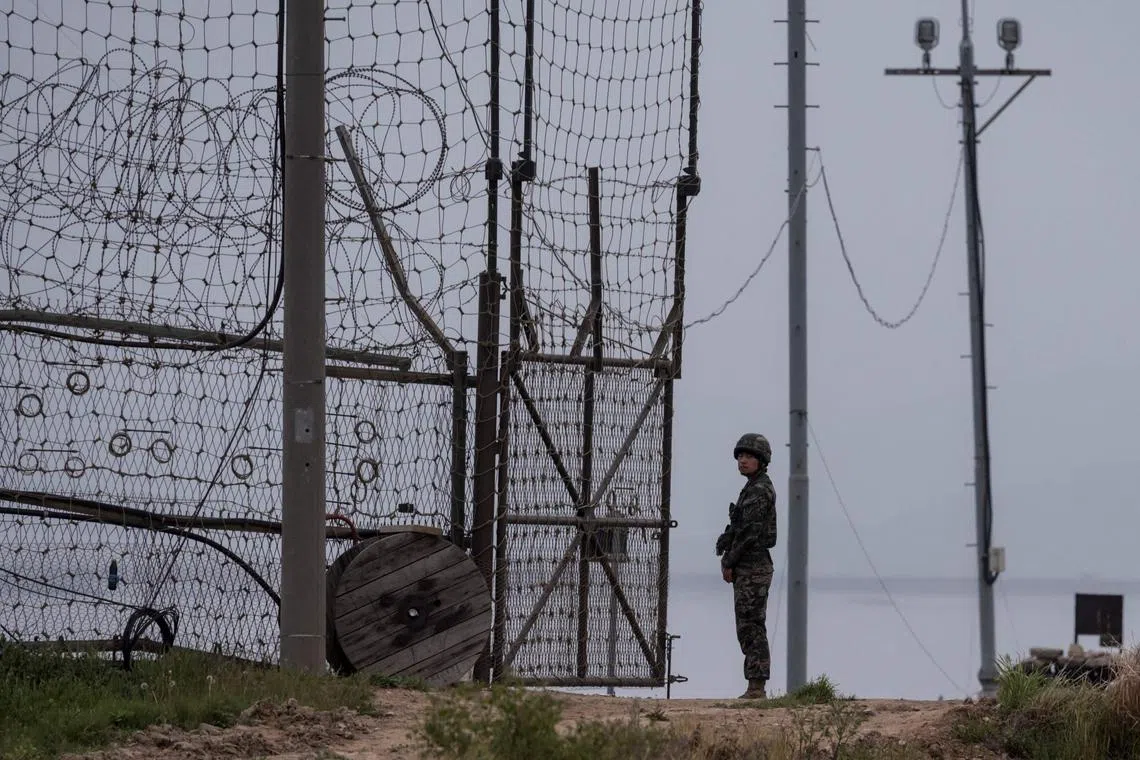 A soldier stands at the fence of the Demilitarized Zone near Ganghwa, South Korea, on May 5, 2017.