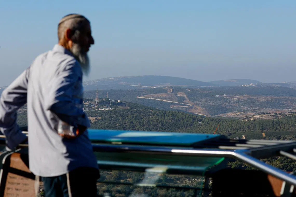 An Israeli resident observes the Israel-Lebanon border, in northern Israel.