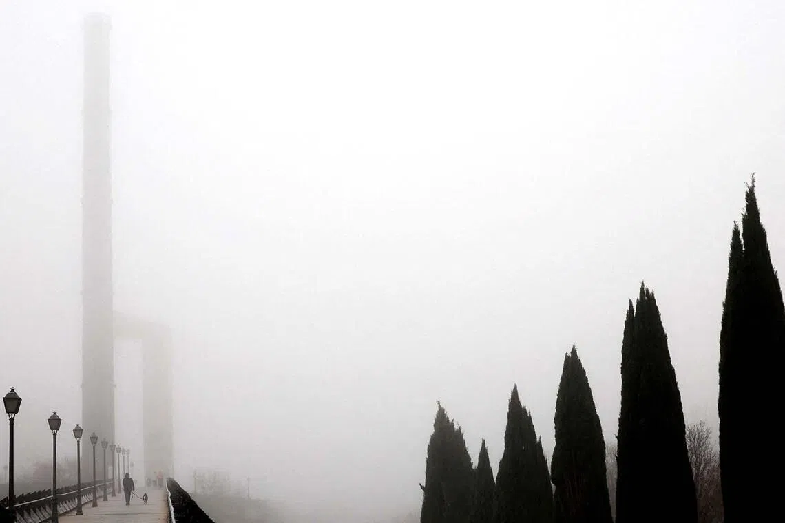 People walking amid dense fog at a park in Madrid, Spain, Jan 15, 2026. 