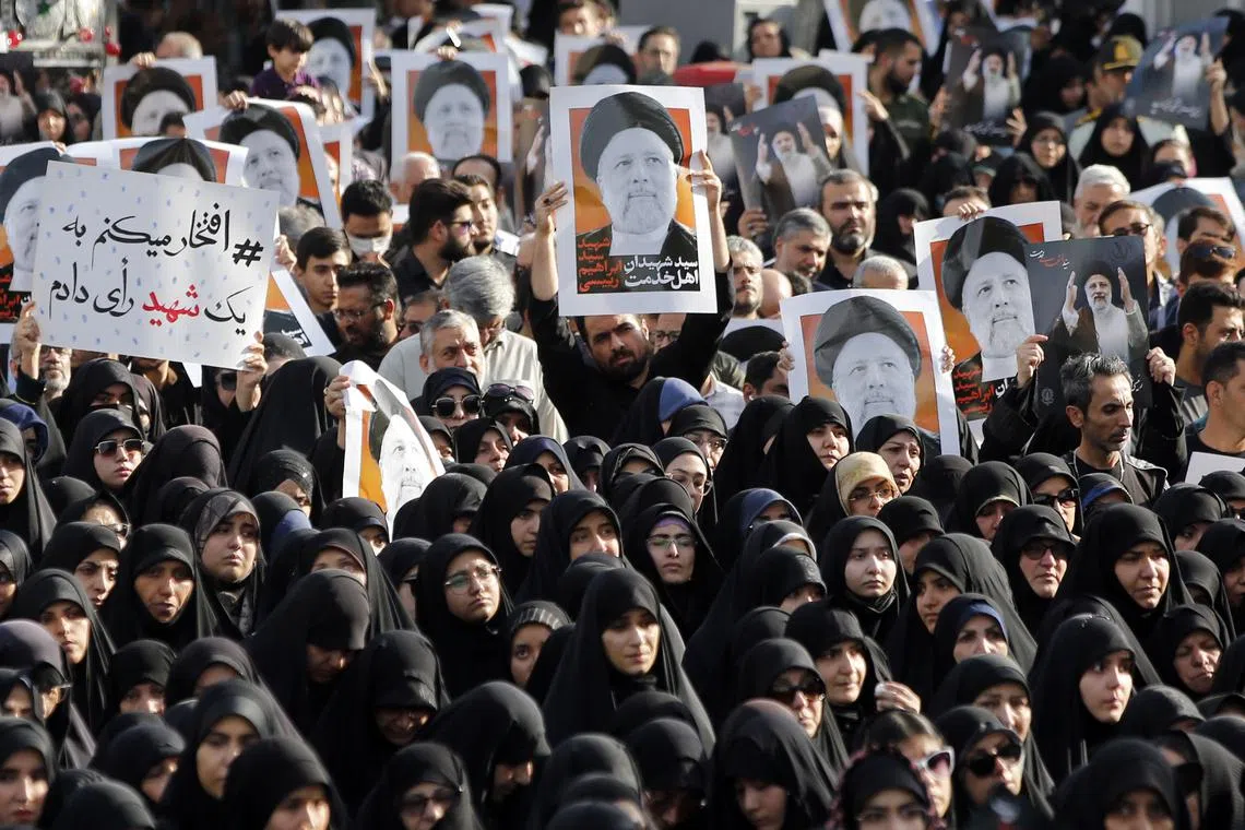 Iranians holding posters of the late Iranian President, Ebrahim Raisi, as they take part in a mourning ceremony in Tehran, Iran, on May 20, 2024. 