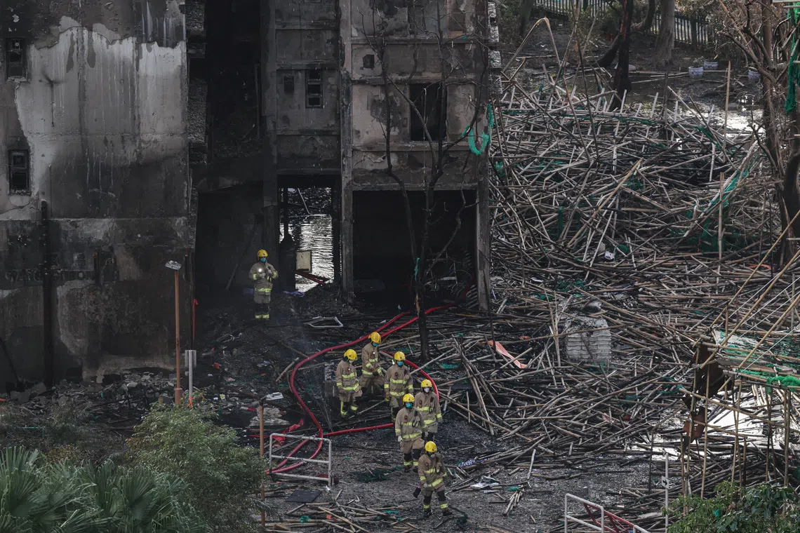 Firefighters walk through charred bamboo scaffolding at Wang Fuk Court housing complex in Tai Po, Hong Kong, on Nov 29.