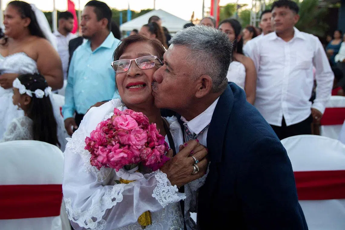 A couple takes part in a mass wedding as part of a Valentine's Day celebration, in Managua, Nicaragua February 14, 2024. REUTERS/Maynor Valenzuela TPX IMAGES OF THE DAY