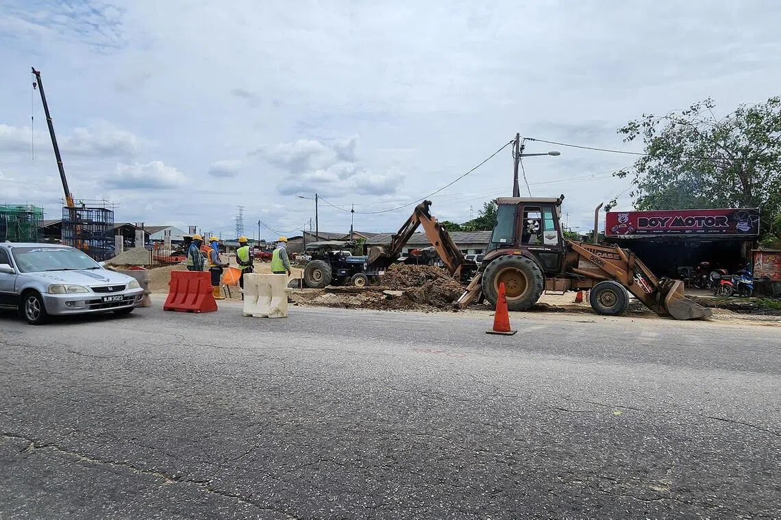 hzwce - Roadworks continue as a partially-completed flyover for a highway in Klang, Malaysia, looms in the background.

CREDIT: HAZLIN HASSAN