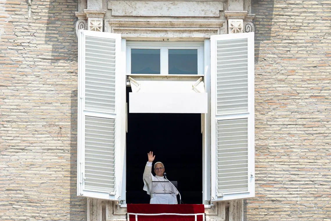 Pope Leo waving after leading the Angelus prayer from a window of the Apostolic Palace at the Vatican on June 29.