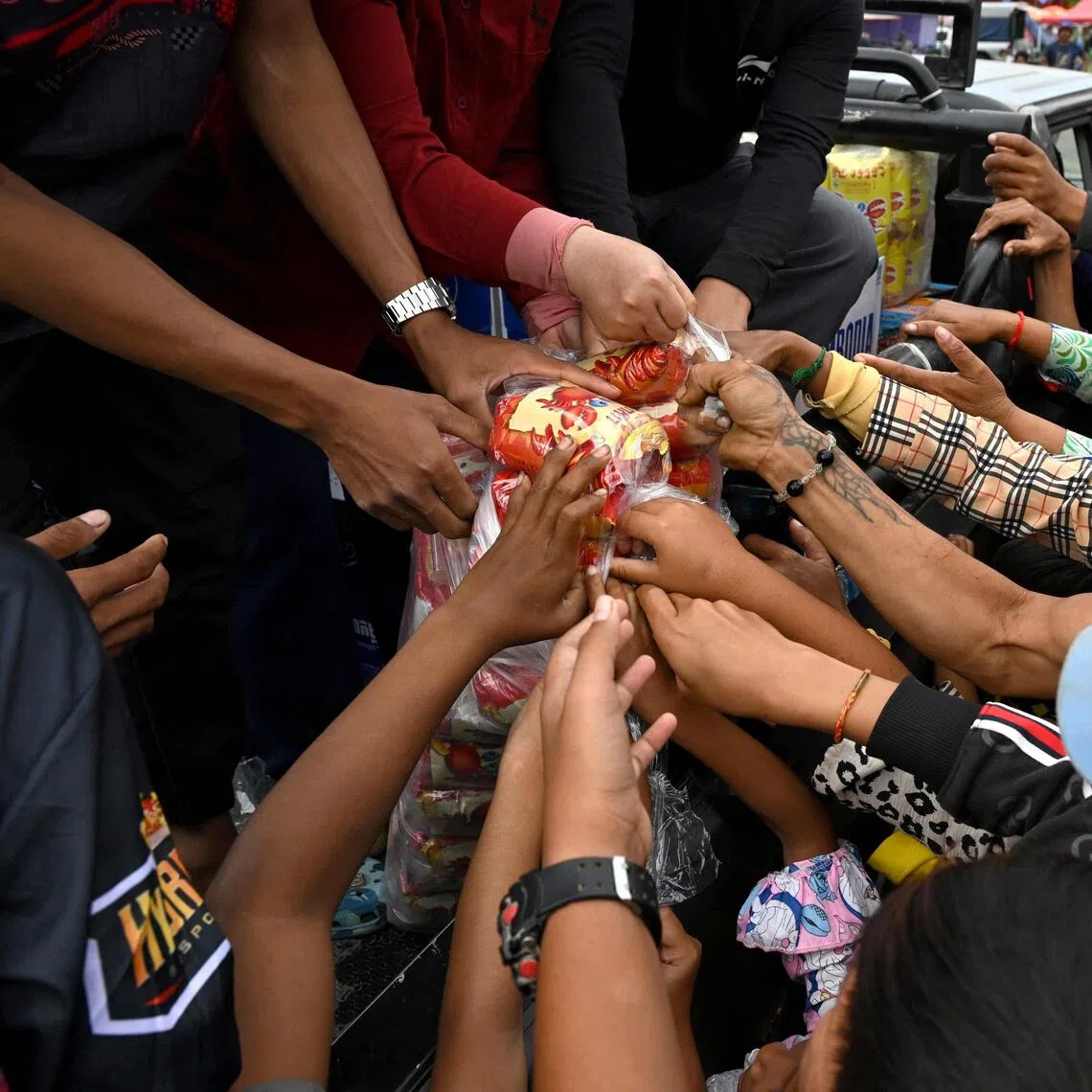 Cambodiands displaced by war gather to receive aid at a temporary camp in Cambodia's Banteay Meanchey province.

