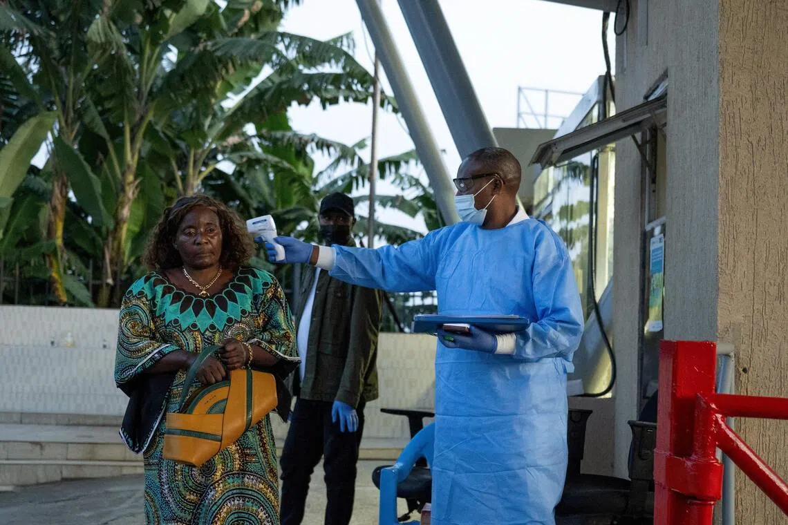 A Congolese health worker checking the temperature of a traveller at the border  between Congo and Rwanda, in Goma, Democratic Republic of Congo, on May 18.