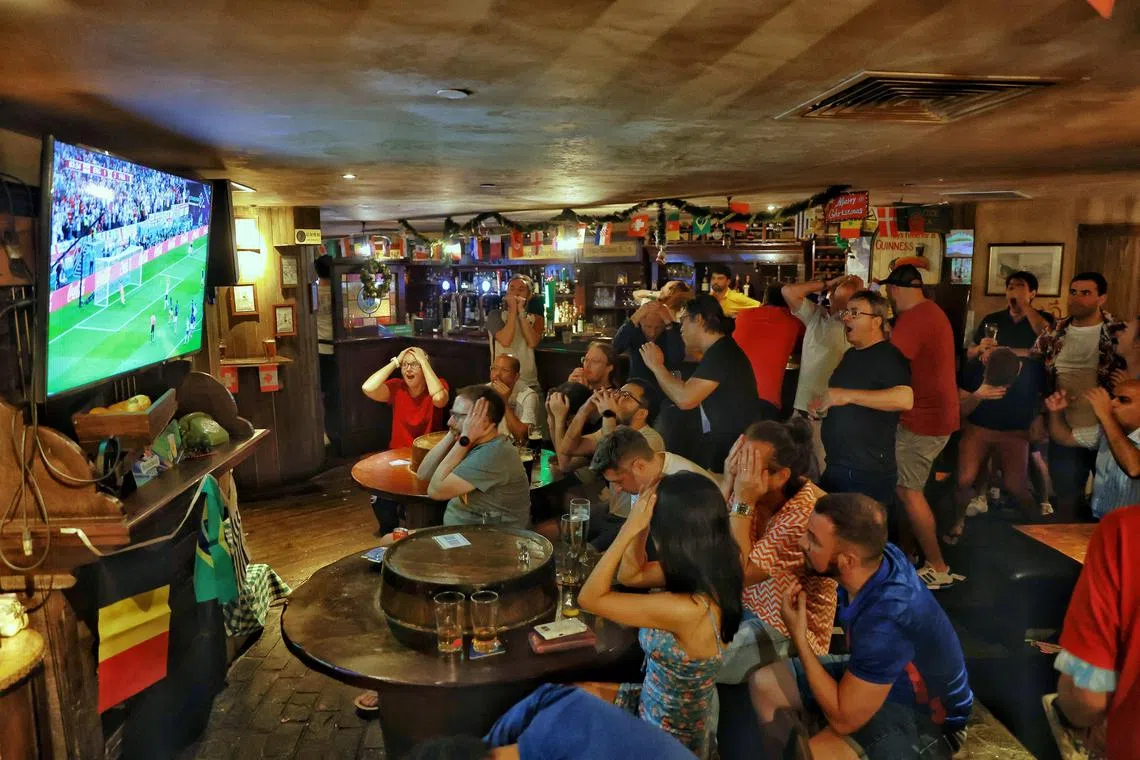 England fans reacting to Harry Kane’s penalty miss during a live screening of World Cup quarter-final match between England and France at Muddy Murphy’s Pub on Dec 11, 2022. ST Photo: Kevin Lim eafrance11