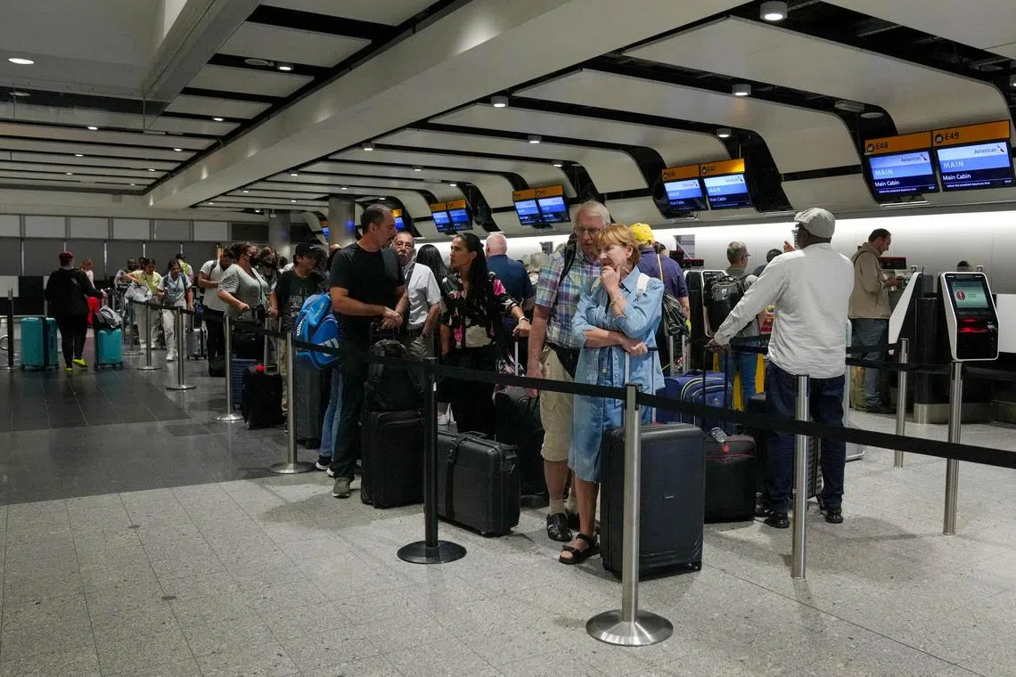 Passengers queue for the check-in desk at Heathrow Terminal 3 in London.