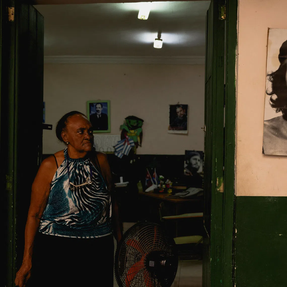 Nerys Navarro, 77, a teacher, poses for a photograph at the entrance of a classroom as Cuba is set to kick off the school year for nearly 1.4 million students, despite a fuel, transportation, and electricity crisis that has brought havoc across all walks of life on the island, in Havana, Cuba August 27, 2026. REUTERS/Norlys Perez