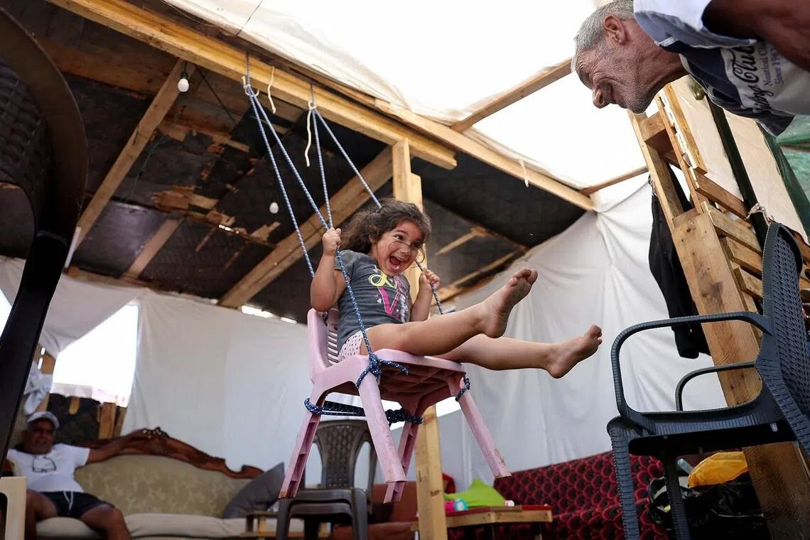 A girl and her grandfather playing inside a tent used as a shelter at Beirut waterfront, Lebanon, June 4.