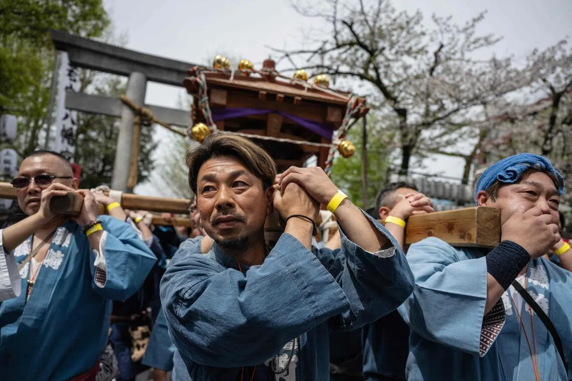 Devotees carry a large phallus-shaped portable shrine during the Kanamara festival at the Kanayama Shrine in Kawasaki on April 5, 2026.  
