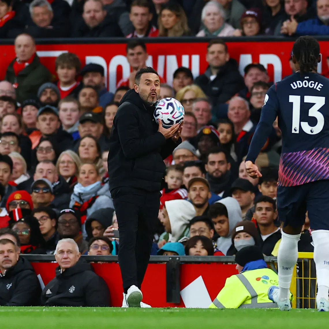 Soccer Football - Premier League - Manchester United v Tottenham Hotspur - Old Trafford, Manchester, Britain - October 10, 2026 Tottenham Hotspur manager Roberto De Zerbi holds the match ball as Destiny Udogie looks on REUTERS/Phil Noble
