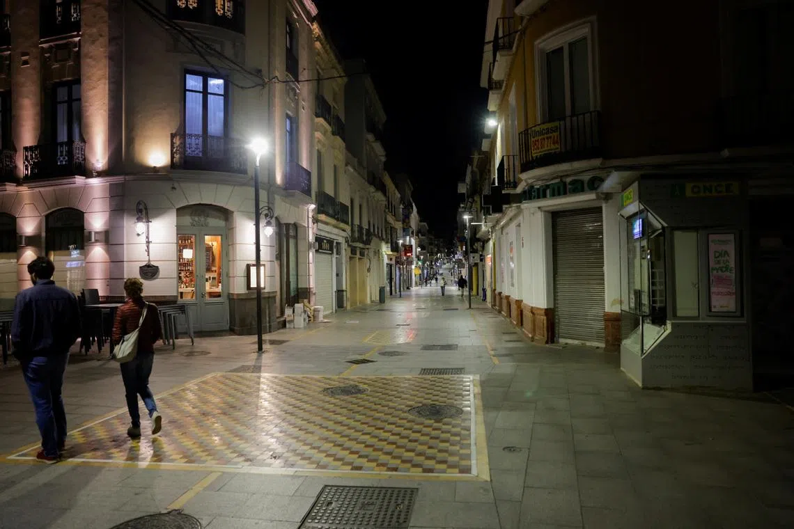 Tourists walk along an illuminated shopping street, the day after a sudden major blackout in the Iberian Peninsula, in Ronda, Spain April 29, 2025. REUTERS/Jon Nazca