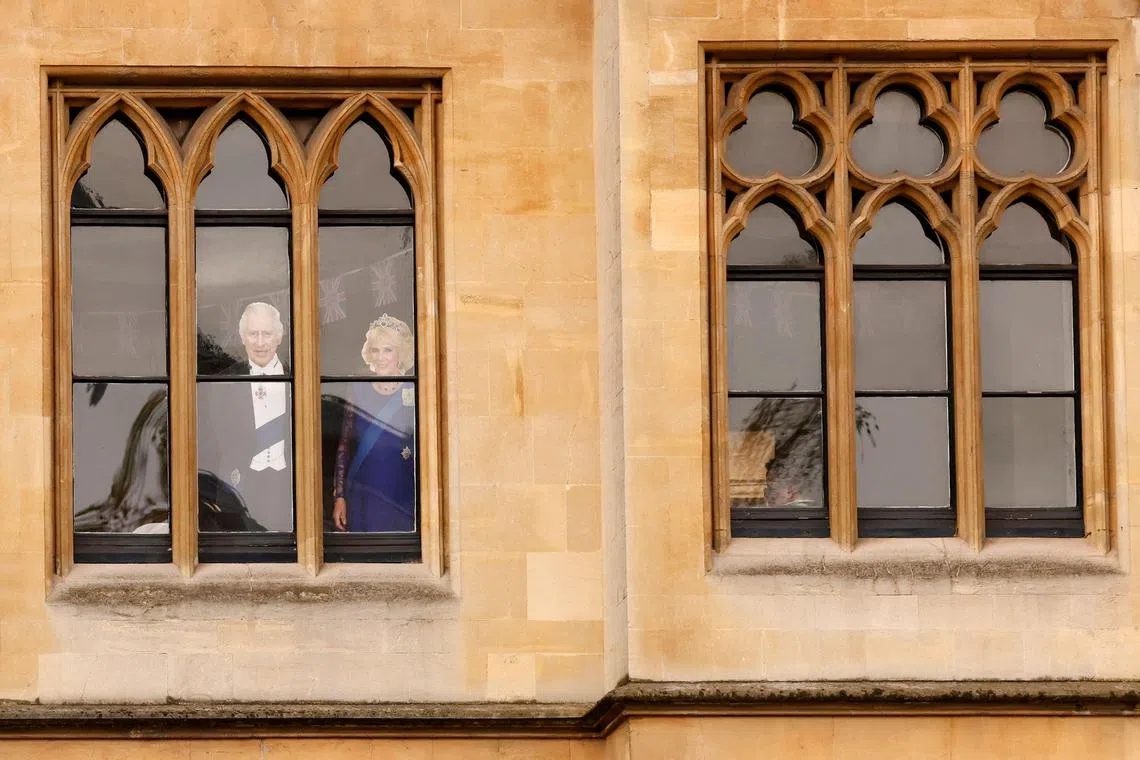 An image of Britain's King Charles III and Britain's Camilla, Queen Consort is pictured in the window of a building overlooking Westminster Abbey in central London on May 6, 2023, ahead of the coronations of Britain's King Charles III and Britain's Camilla, Queen Consort.