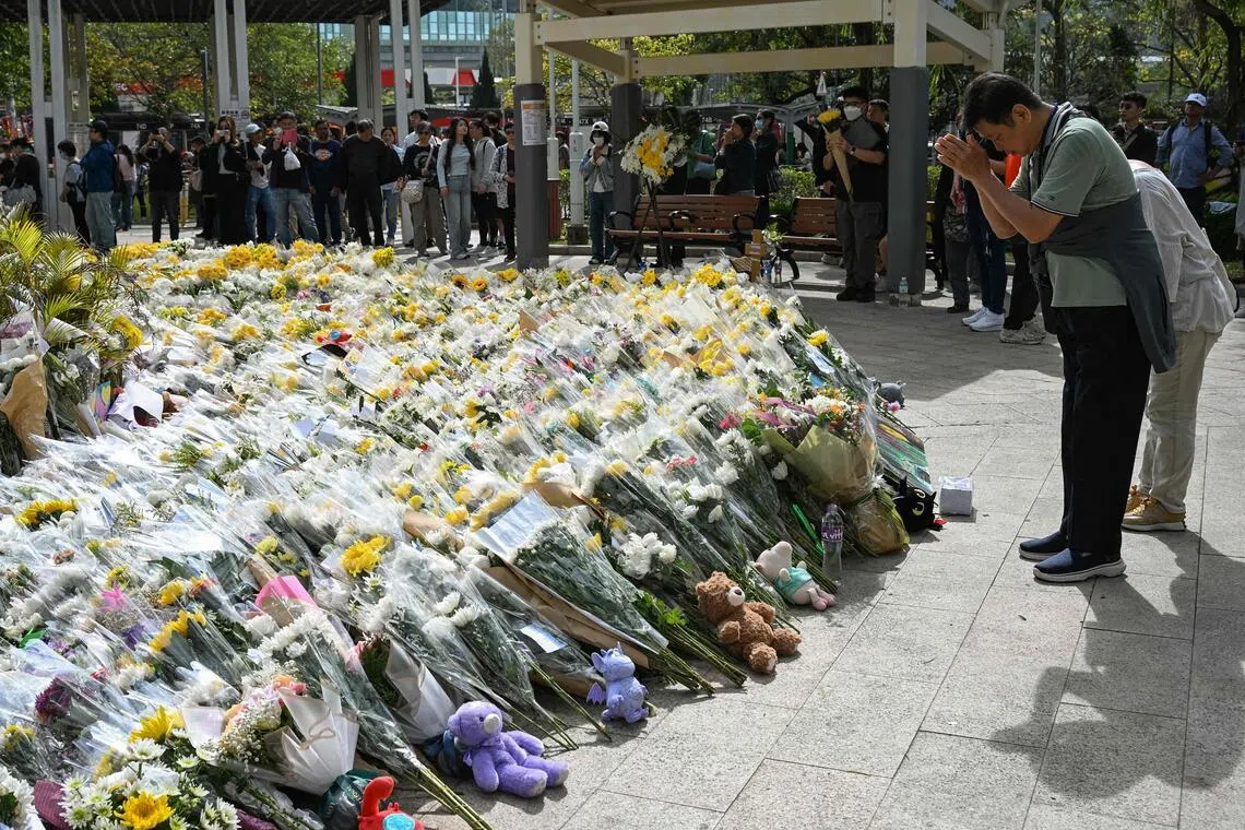 People lay flowers outside the Wang Fuk Court apartment blocks in the aftermath of the deadly fire on Nov 26, 2025, in Hong Kong's Tai Po district on Dec 1, 2025.