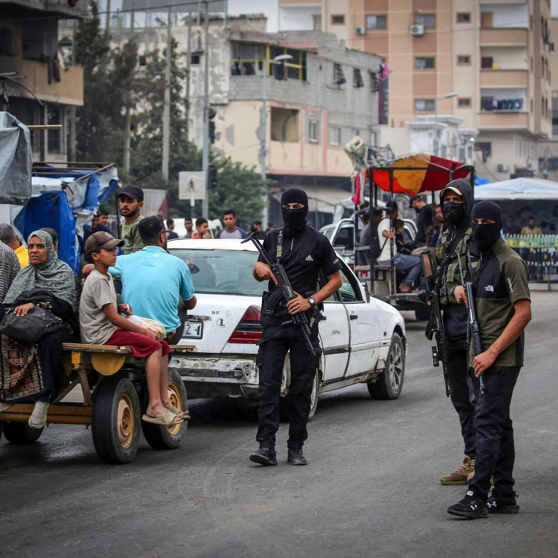 Members of the internal security forces loyal to the Palestinian group Hamas are deployed in the Nuseirat refugee camp in the central Gaza Strip, as displaced people return to Gaza City, on October 12, 2025. Israel declared a ceasefire in Gaza and began to pull back its forces on October 10, as tens of thousands of exhausted Palestinians made their way back to their devastated homes. (Photo by Eyad BABA / AFP)