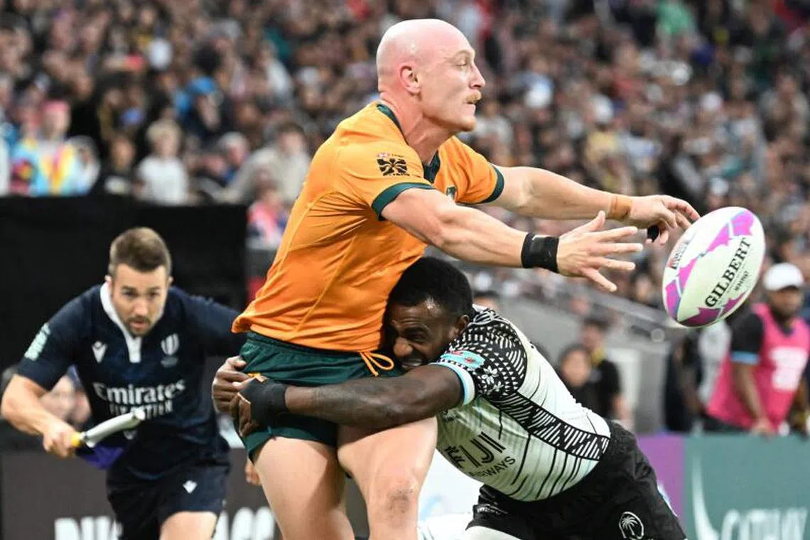 Australia’s James Turner fends off Fiji’s Filipe Sauturaga during the men’s third place playoff match between Fiji and Australia on the third day of the 2025 Rugby Sevens Hong Kong tournament at the Kai Tak sports stadium on March 30, 2025. (Photo by Peter PARKS / AFP)