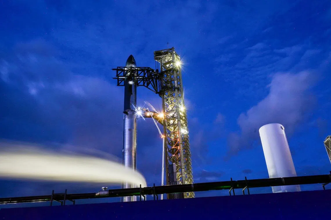 Technicians work from a lift bucket before sunrise as preparations to launch a SpaceX Starship spacecraft continues, at the company's complex in Starbase, Texas, U.S., August 25, 2025. REUTERS/Steve Nesius