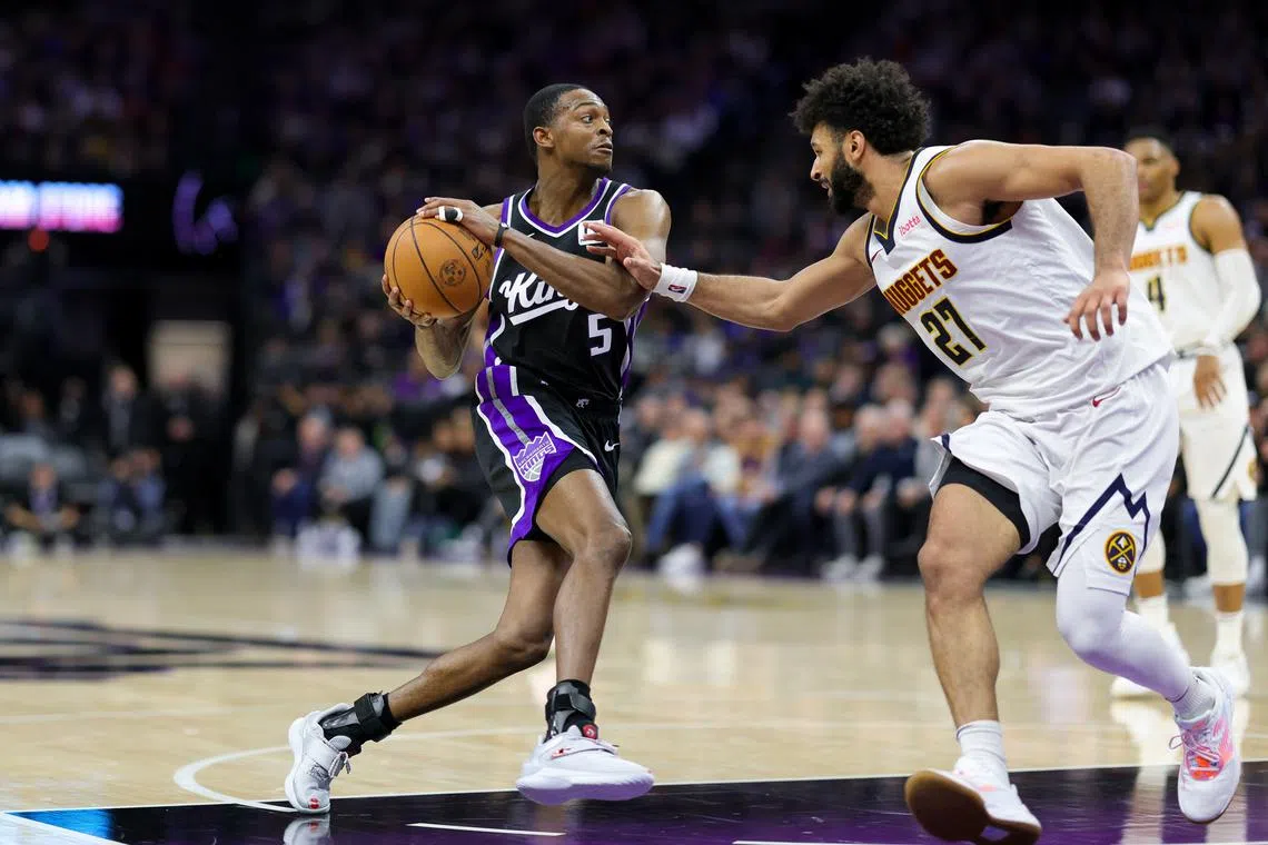 Dec 16, 2024; Sacramento, California, USA; Sacramento Kings guard De'Aaron Fox (5) controls the ball against Denver Nuggets guard Jamal Murray (27) during the third quarter at Golden 1 Center. Mandatory Credit: Sergio Estrada-Imagn Images
