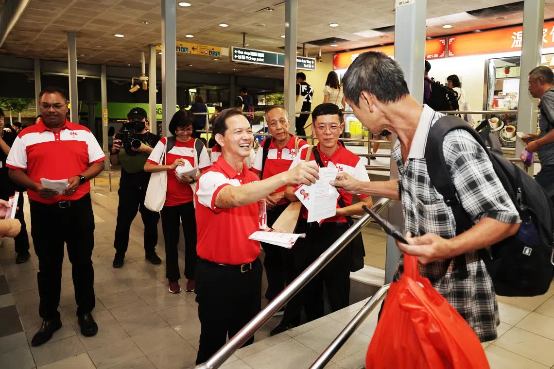 PSP chief Leong Mun Wai (centre) passing a supporter a PSP leaflet during walkabout with Sani Ismail (far left) at Lakeside MRT area on April 25.