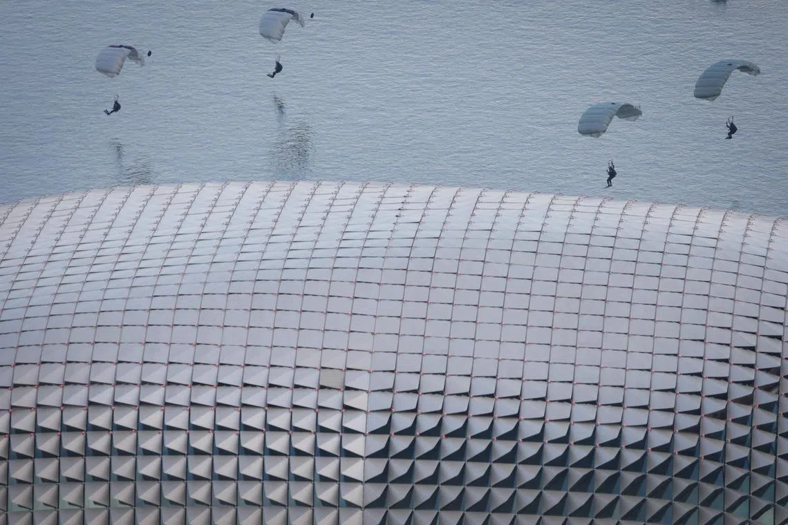 Naval divers parachuting into Marina Bay near the Esplanade during National Day Parade (NDP 2025) held at Padang as seen from Swissotel The Stamford