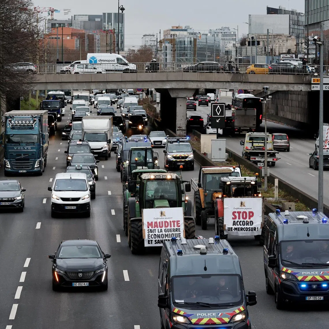French farmers of the Confederation Paysanne drive their tractors slowly on the Paris ring road during a \"Go Slow\" protest against the government's handling of the EU-Mercosur free trade agreement and the handling of the lumpy skin disease outbreak, in Paris, France, January 9, 2026. The slogans read  \"Damn this economic and health war\" and \"Stop the EU-Mercosur agreement\".  REUTERS/Benoit Tessier