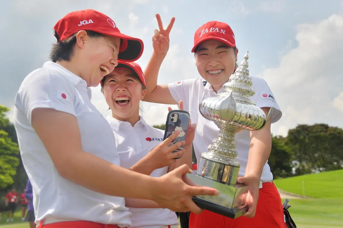 Japan’s golfers (from left) Mizuki Hashimoto, Ayaka Tezuka, and Miku Ueta laughing at their wefie with the trophy after beating New Zealand to win the Queen Sirikit Cup at Laguna National on May 27, 2022.