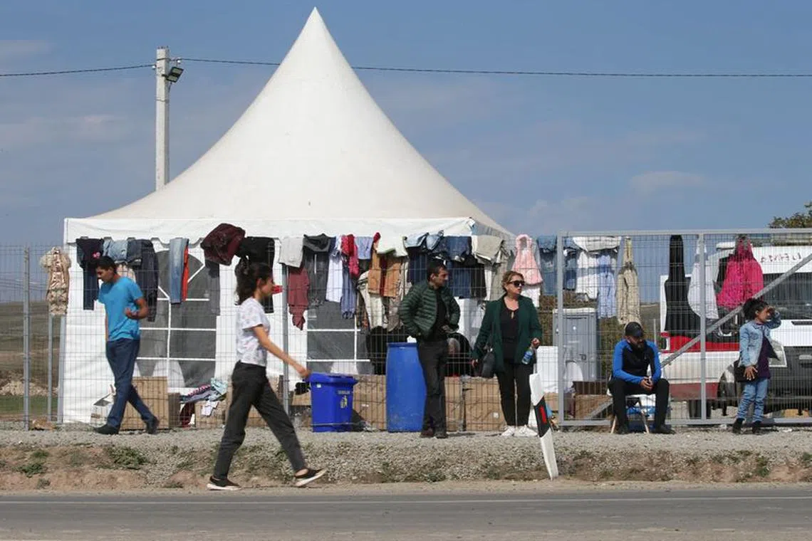 People gather near an aid center for refugees from Nagorno-Karabakh region in the border village of Kornidzor, Armenia, September 29, 2023. REUTERS/Irakli Gedenidze
