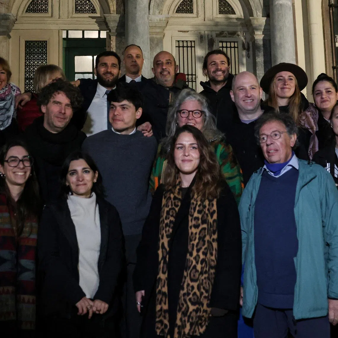Aid workers, including Sean Binder and Sarah Mardini pose with other aid workers involved in refugee rescues, after the verdict in their trial at the town of Mytilene on the island of Lesbos, Greece, January 15, 2026. REUTERS/Elias Marcou