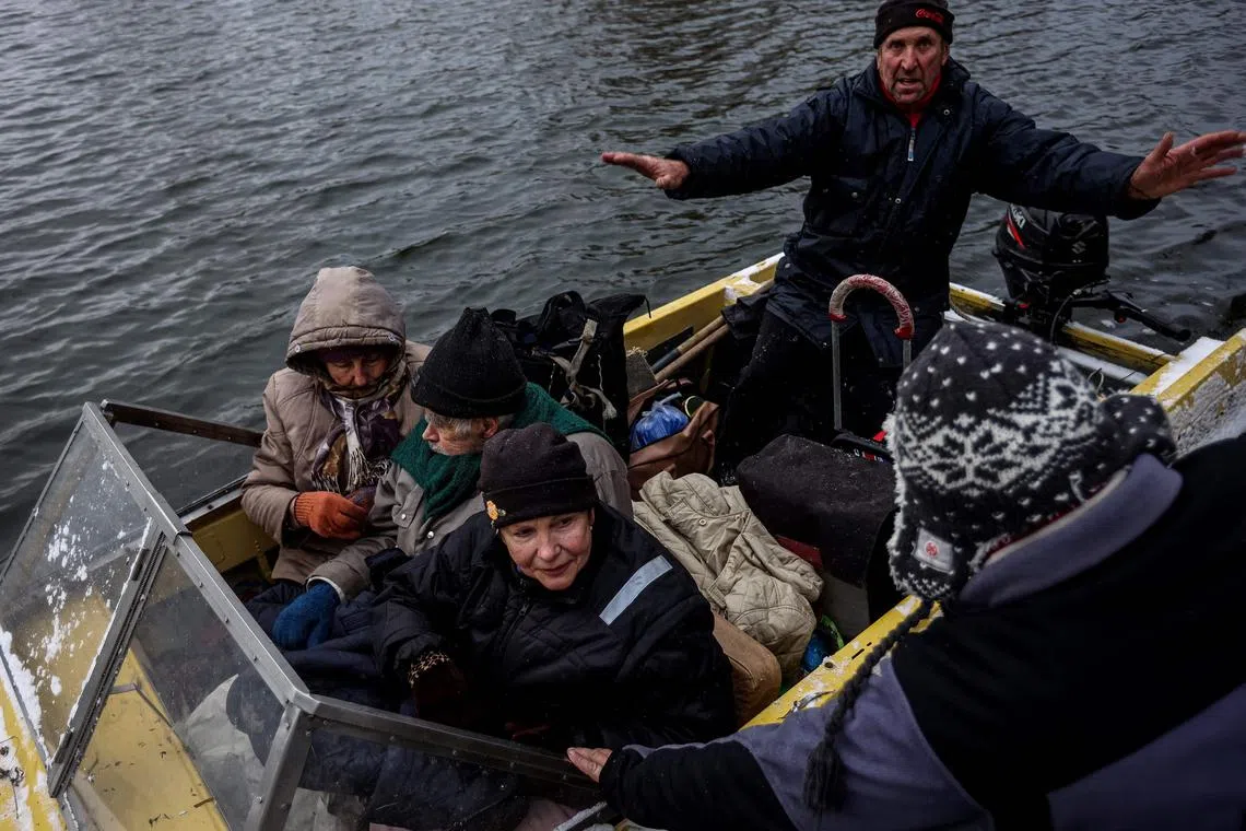 People are evacuated from a holiday village on Potyomkinskyi island, on the Dnipro river, near Kherson.