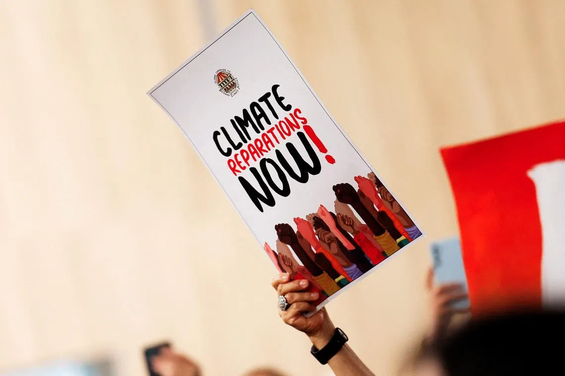 An environmental activist holds a flyer during a protest to urge world leaders to commit to a strong climate finance deal during the United Nations Climate Change Conference (COP29), in Baku, Azerbaijan November 16, 2024. REUTERS/Maxim Shemetov