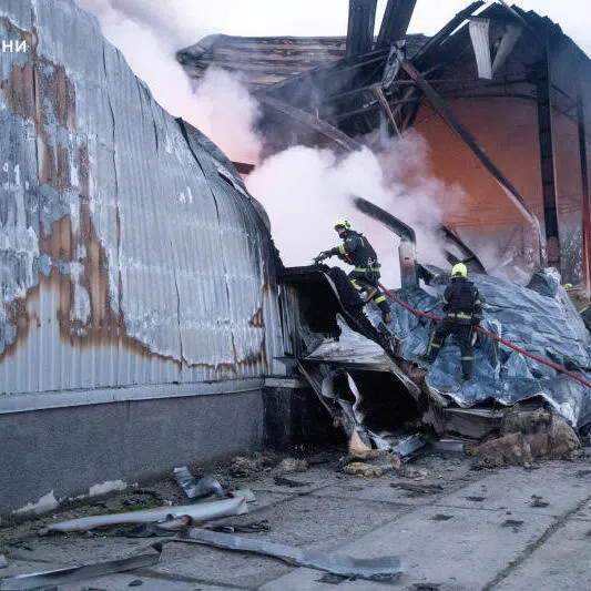Firefighters work at the site of a warehouse of home appliances which was hit during an overnight Russian drone strike in Odesa, Ukraine on Dec 16.