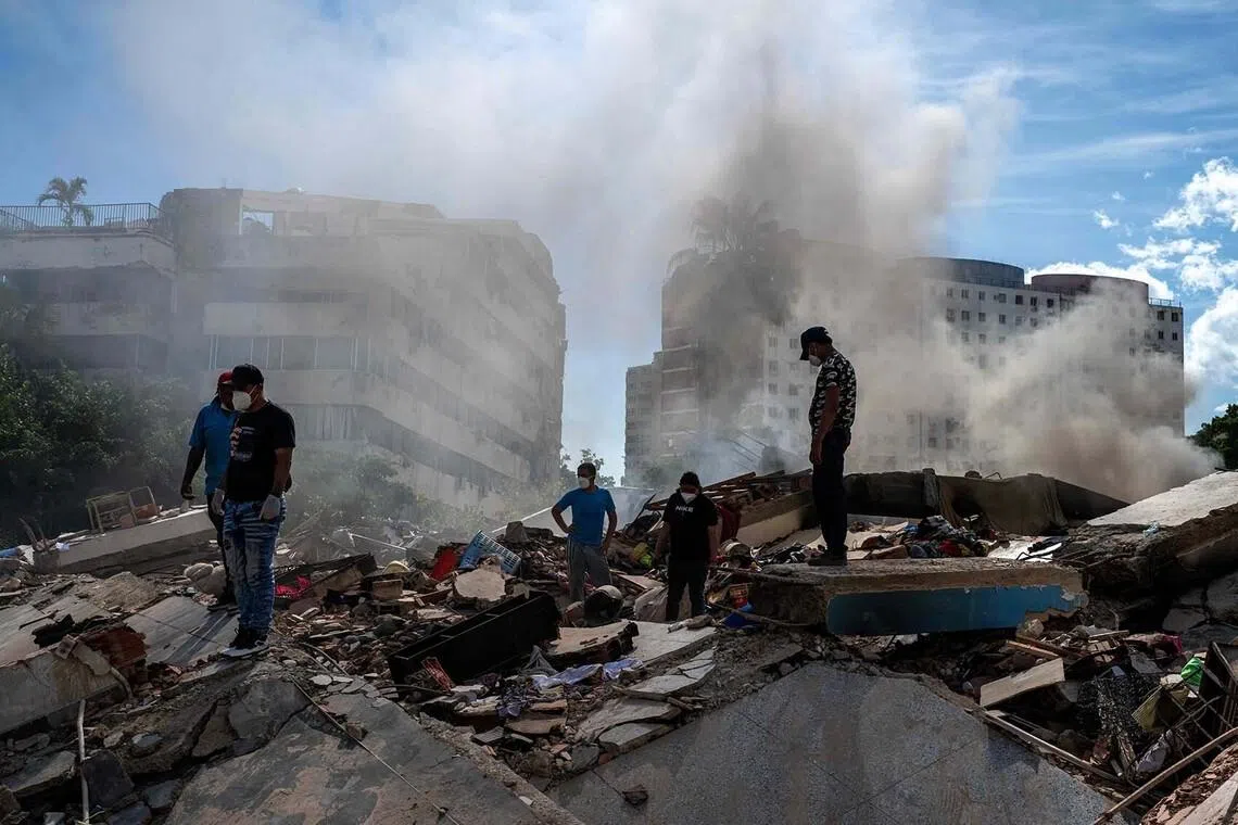 TOPSHOT - Rescuers and volunteers search for survivors in La Guaira, La Guaira state, Venezuela, on June 28, 2026, following twin earthquakes. Thousands of rescuers, relatives and volunteers dig day and night through mounds of concrete to find survivors of the earthquakes that struck Venezuela more than three days ago, leaving nearly 1,500 dead and tens of thousands missing. (Photo by Miguel MEDINA / POOL / AFP)