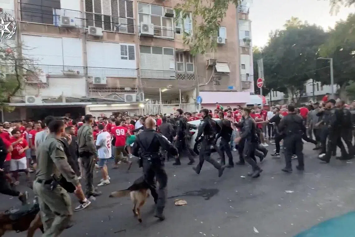 Israeli law enforcement personnel disperse a crowd of football club supporters outside Bloomfield Stadium in Tel Aviv, after a Premier League match between Hapoel and Maccabi was cancelled due to what police said was public disorder and violent riots, in this screengrab from video released on Oct 19, 2025.