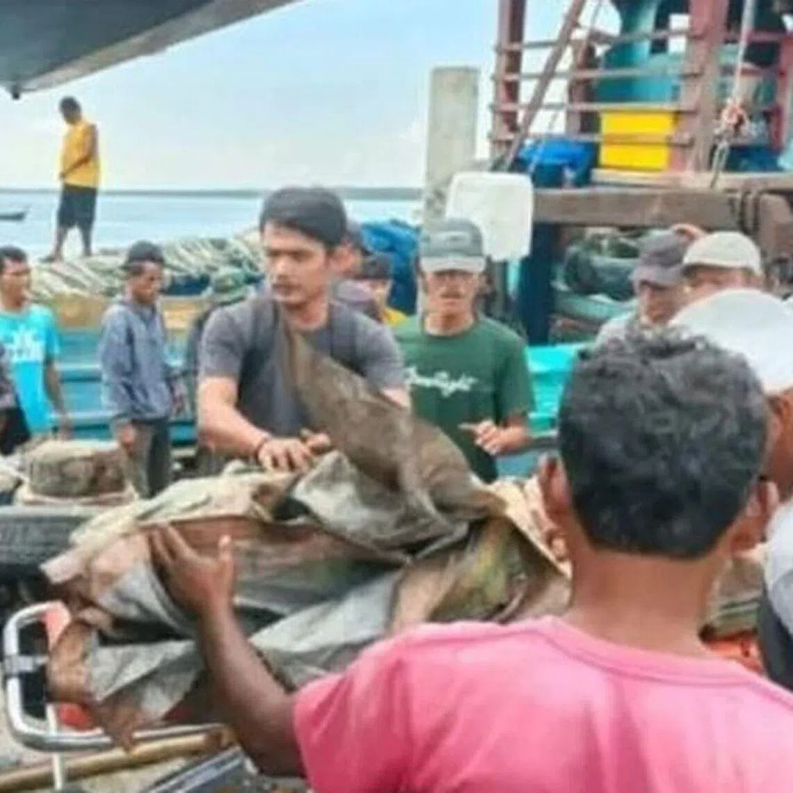 Crew members rescued from a burning fishing boat arrive at Belawan Port in Medan, North Sumatra, on April 7.