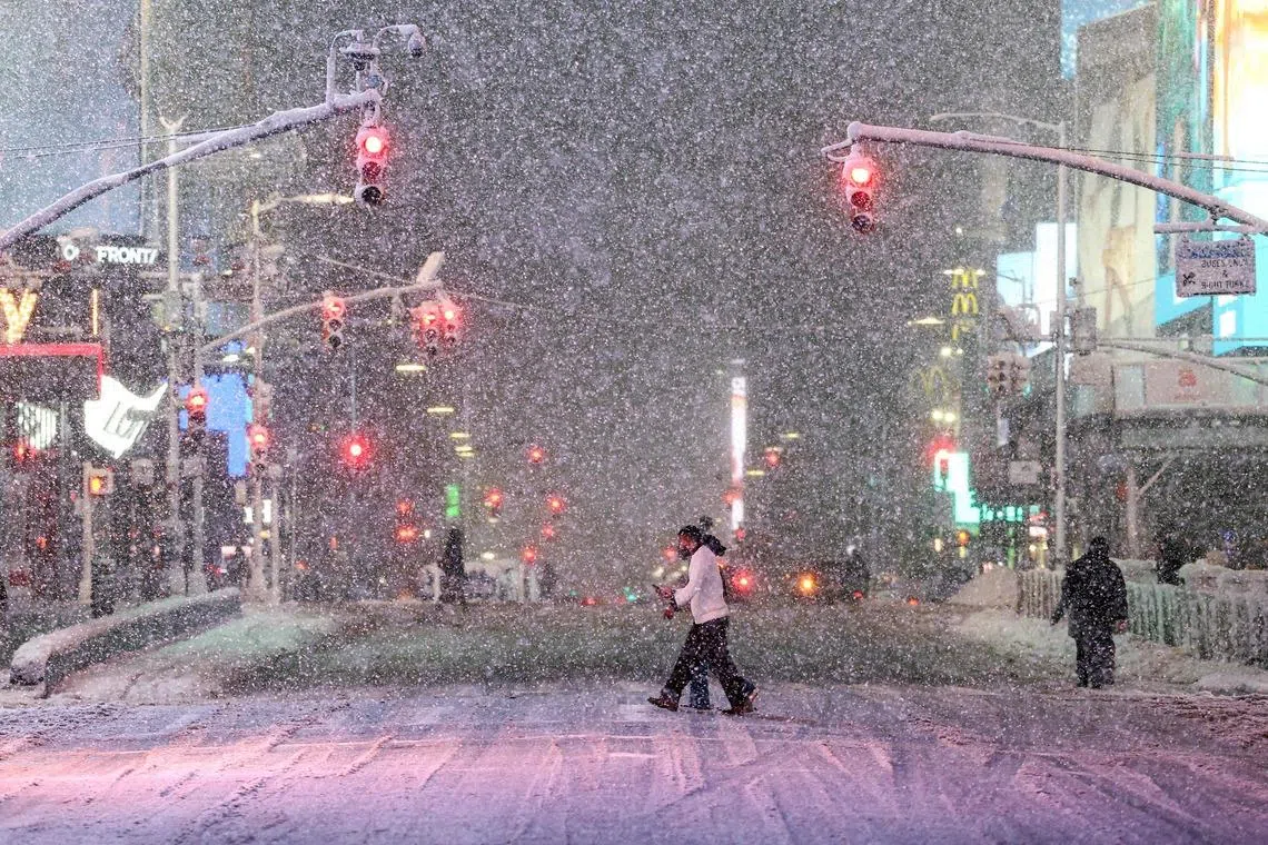 Pedestrians walking along Manhattan's Times Square during a snowfall in New York City, US on Feb 22, 2026. 