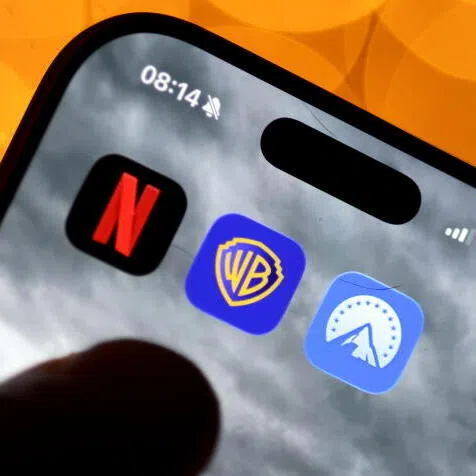 The app logos of Netflix, Warner Brothers and Paramount are seen on a smartphone display.