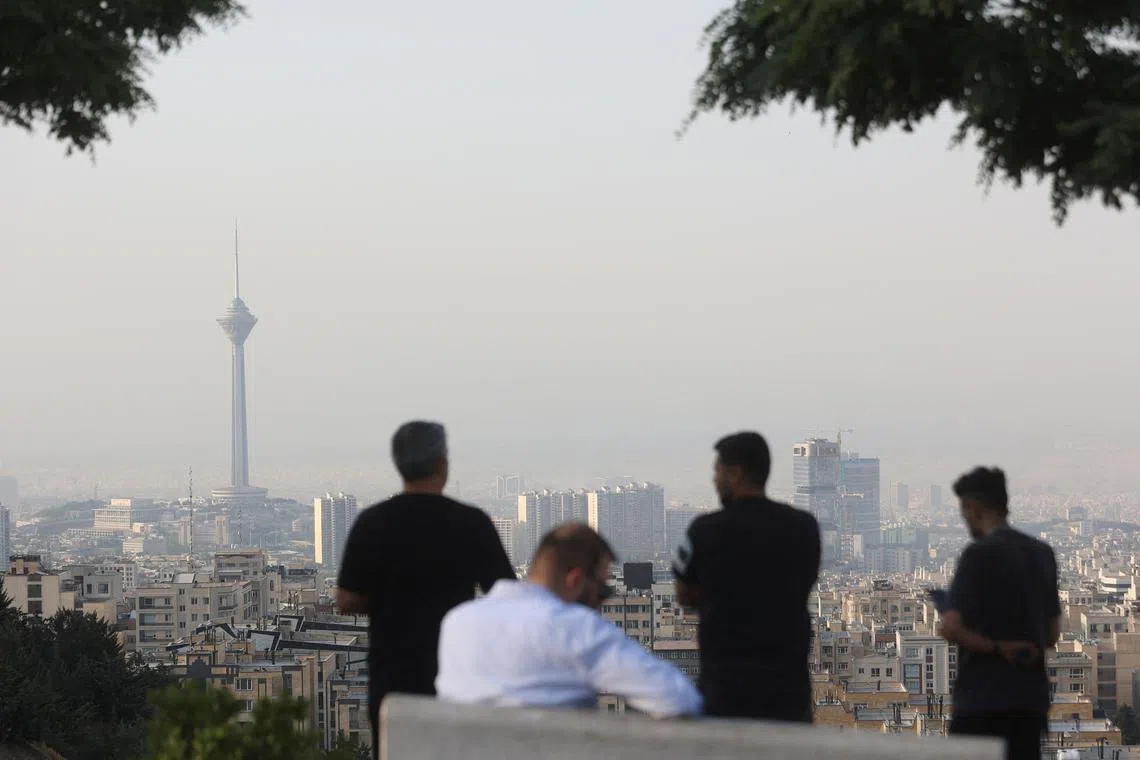 Men view the cityscape in the aftermath of Israeli strikes, in Tehran, Iran, June 13, 2025. Majid Asgaripour/WANA (West Asia News Agency) via REUTERS