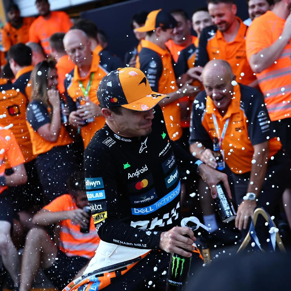 McLaren driver Lando Norris celebrates with the team after a one-two finish in the Formula 1 Austrian Grand Prix.