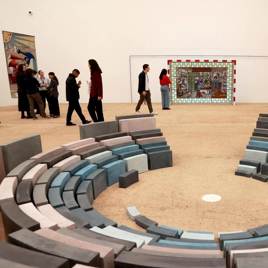 People view works during the opening of the exhibition 'Football and Art: A Shared Emotion' in Mexico City. Recycled seats from the former Azteca Stadium, scaled-down dirt football fields, and historical archives of football around the world are among the hundred works on display at the Jumex Museum in the lead-up to the 2026 World Cup. 