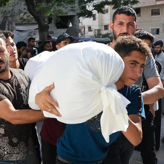 Mourners carry the body of a Palestinian killed in an Israeli strike, according to medics, at Al-Shifa Hospital in Gaza City, on June 14.