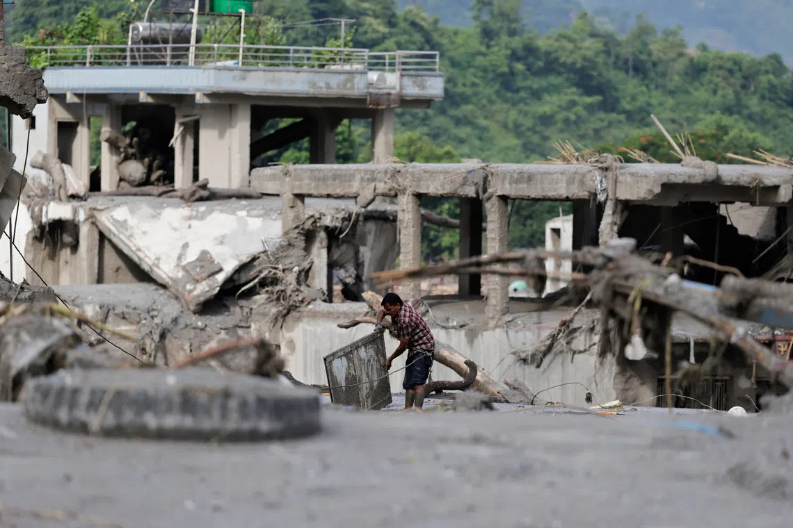 A man salvages his belongings from mud following devastating floods, in Trishuli in Nuwakot district, Nepal, August 27, 2026. REUTERS/Navesh Chitrakar